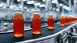 © Pixel-Tropic - Bottles of amber liquid moving on a conveyor belt in a factory.