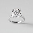 © amaf - A solitaire diamond ring with a large, round brilliant-cut stone set in a simple, four-prong setting on a thin, white gold band.  The ring casts a subtle shadow on a light grey background
