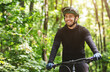 © Prostock-studio - Joyful male bicyclist cycling in mountain forest in sun flares, enjoying the view, copy space