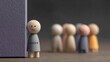 © Wan - Introverted Leadership Concepts. A wooden figure labeled 'LEADER' stands quietly apart from a blurred group of figures, symbolizing calm leadership, and the power of presence without noise.