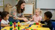 © Ura - Teacher interacting with children in a classroom setting focusing on education and early childhood development depicting reading learning and play activities as an education concept with diversity