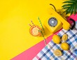 © Aqsa - Summer creative layout with cocktail glass, lemons, drinking straws, ice cubes and yellow retro telephone with palm leaf on bright yellow and plaid background