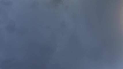 Wall Mural - a vertical up shot of a lighning bolt cloud-to-cloud in a dramatic stormy sky at night.