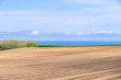© dah_keni - Long rows of raised beds stretch across the hilly terrain near the coast in Hokkaido, Japan