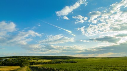 Wall Mural - shooting stars in the sky at sunset. meteor trails above the clouds, dreamy landscape. fireballs fly