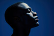 © AnnaStills - African American mans profile in dramatic blue lighting, showing strong facial features and shadows highlighting contours, creating striking image and mood