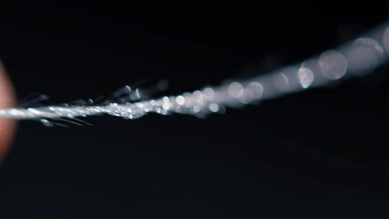Poster - Close-up of a Hand Twisting a Fiber Optic Coil with Fine Detailing in Focus
