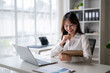 © Wasana - Young asian businesswoman working with documents and laptop in office
