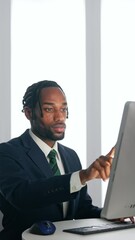 Poster - A black male business person working on a desktop PC in an office