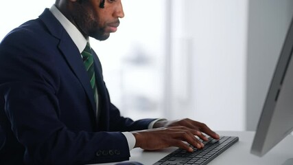 Poster - A black male business person working on a desktop PC in an office