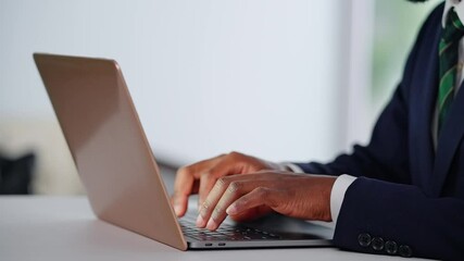 Poster - A black male business person working on a laptop at a desk in an office