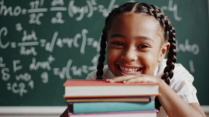 Aufkleber - Joyful elementary school student with braided hair leaning on a stack of colorful textbooks, smiling at the camera in a classroom with a chalkboard full of math equations in the background