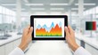 © PrusarooYakk - eco-conscious consumer concept. Hands holding a tablet displaying colorful data graphs in a lab setting.