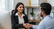 © Bboy - Happy young Indian business owner women shaking hands with male partner at meeting table, hiring new employee after interview,