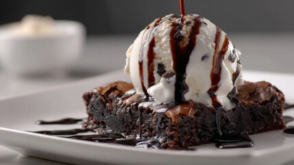 Poster - A close-up of a chocolate brownie topped with a scoop of vanilla ice cream and drizzled with chocolate sauce, creating an indulgent dessert scene