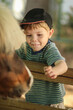© Austockphoto - Young boy patting a pony at the show