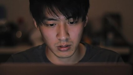 Man using laptop at night, blurred background