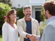 © SolaruS - Happy couple shaking hands with a professional outside their home. Represents trust, success, and new beginnings. Great for finance, real estate, or achievement concepts.