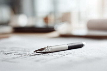 Poster - Closeup of a pen lying on architectural blueprints, symbolizing planning, design, and construction. Ideal for business, architecture, or engineering concepts.