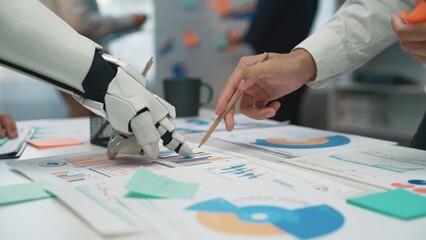 Poster - a modern office scene showcasing collaboration between a robotic hand and a human hand, analyzing va