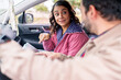 © Guillermo Spelucin - Couple traveling deciding best route using ipad map inside car