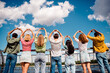 © deagreez - Group of young friends outdoors showing heart gestures on a sunny day, celebrating friendship and unity together
