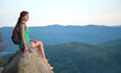© bilanol - Young woman hiker sitting alone on rocky mountain enjoying view of summer nature on wilderness trail. Active way of life concept