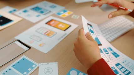 Poster - Excellent startup company employee presenting user interface prototype for mobile application to smart co-worker in office workspace. UX UI designer explain function of icon design on paper. Synergic