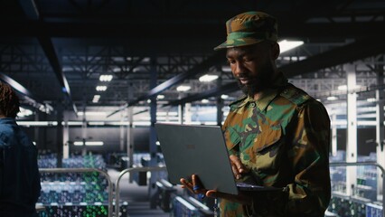 Poster - Army information technology specialist in data center troubleshooting military computer systems and networks using laptop. Soldier in command center server room using notebook,