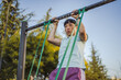 © Miljan Živković - japanese woman doing pulls up on bar at outdoor open gym in park