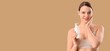 © Pixel-Shot - Young woman with bottle of skincare product on beige background with space for text