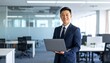 © 순단 강 - A Korean man in a suit holding a laptop computer to the right, with luxury office furniture in the blurred background