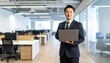 © 순단 강 - A Korean man in a suit holding a laptop computer to the right, with luxury office furniture in the blurred background