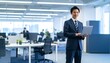 © 순단 강 - A Korean man in a suit holding a laptop computer to the right, with luxury office furniture in the blurred background