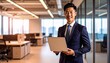 © 순단 강 - A Korean man in a suit holding a laptop computer to the right, with luxury office furniture in the blurred background