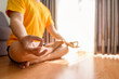 © Leo Lintang - Man meditating in the lotus position on yoga at home for a healthy lifestyle and body care. Meditation and yoga practices concept