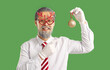 © Studio Romantic - Handsome man dressed in festive clothing, pretending being Santa Claus, pointing at Christmas tree decoration, isolated over green background. New Year is coming soon, think about decor