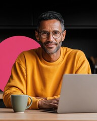 Leinwandbilder - Remote Work Productivity with Attractive Middle Eastern Man Smiling at Laptop in Modern Home Kitchen Showing Flexible Career Growth and Digital Empowerment