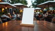 © Rocky - Blank menu holder on a wooden table at a restaurant patio with blurred diners