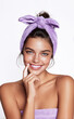 © Irina - Portrait of beautiful young smiling woman with lilac headband wrapped in white towel. Woman holds hands near face on white background. Facial care concept, spa treatments