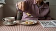 © Yuriy - Elderly caucasian woman enjoying breakfast with coffee and crossword puzzle at home