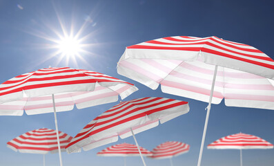 Wall Mural - red striped beach umbrellas against blue sky on sunny day