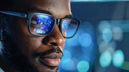 Close up portrait of African American man wearing glasses reflecting screens in eye with bokeh background in blue tones