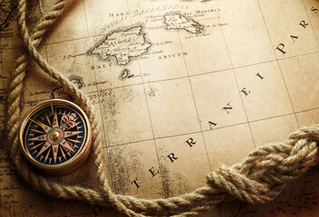 Poster - Magnetic old compass and. rope on world map. Travel, geography, history, navigation, tourism and exploration concept background. Retro compass on geography map.