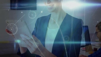 Poster - Mature woman tapping tablet and activating digital blue flares, circles and nodes in tech office