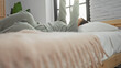 © Krakenimages.com - Woman relaxing on bed in cozy bedroom, dressed comfortably, with modern decor and soft lighting, conveying a peaceful and serene morning atmosphere indoors.