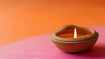 Poster - A single lit candle sits on top of a pink table, simple and elegant