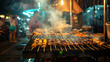 © Yhogi - A vendor prepares satay, Indonesia’s iconic skewered meat dish, grilling over live charcoal with smoke and rich aroma filling the air.