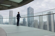 © ReeldealHD images - Businessman looking out at City Skyline from High Rise