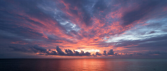 Poster - Dramatic sky sunset cloud ocean horizon colorful tranquil nature scene with vibrant light reflection